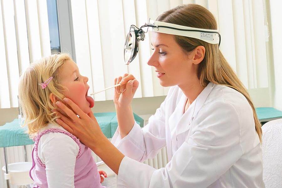 Доктор проверяет больное горло ребенка