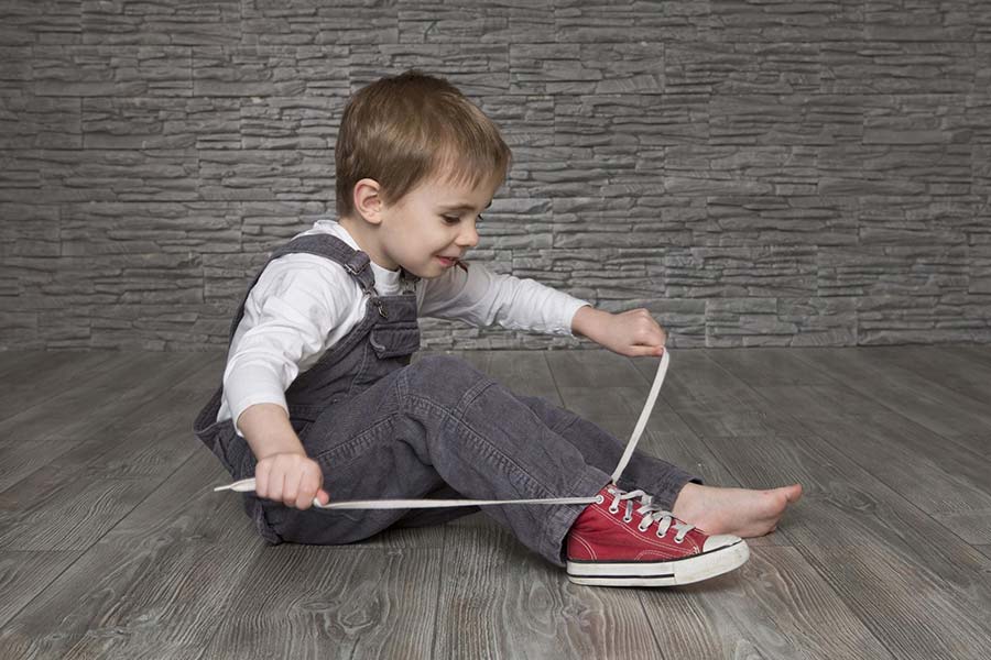 Мальчик завязывает шнурки сам